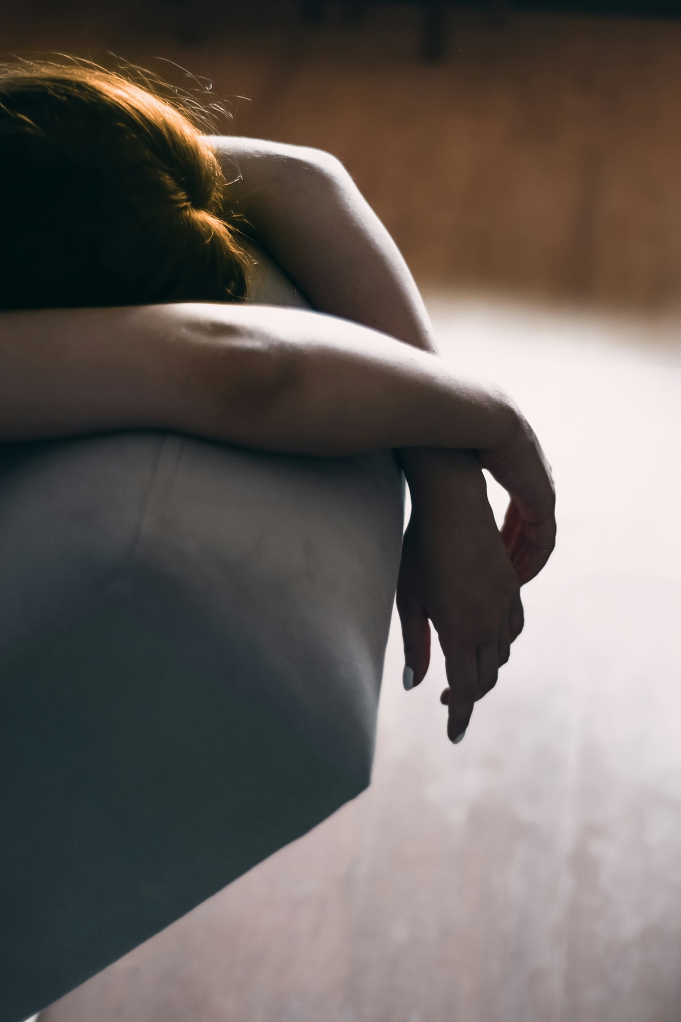 Frau sitzt ruhig auf dem Sofa — die stille Last früher Erfahrungen